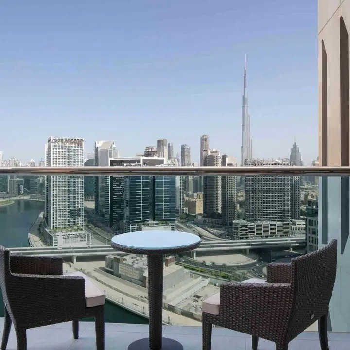 two chairs on a balcony with the view of dubai in the background