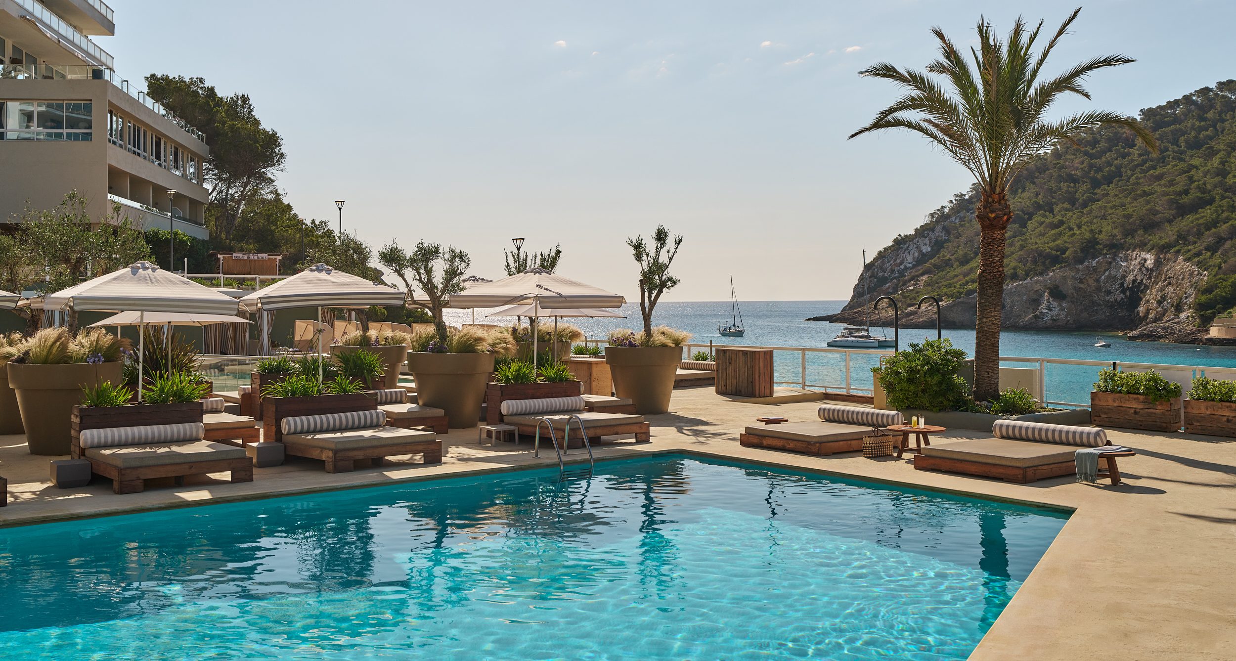 image of pool with sunbeds around it and sun umbrellas