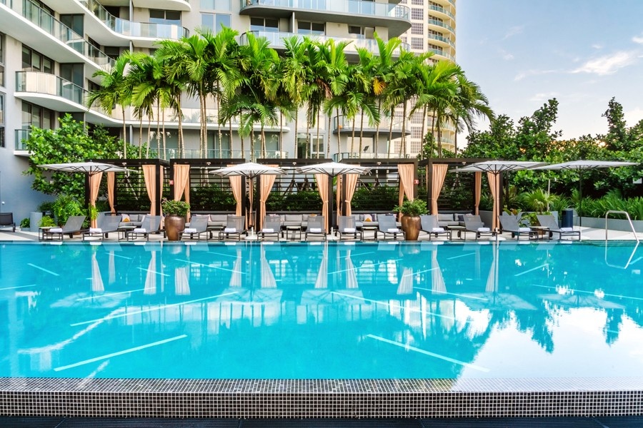 Pool at Hyde Midtown Miami with a row of cabanas by the side of the pool