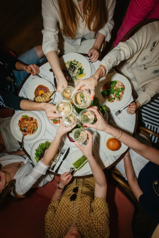 a table, with food and drinks, and people enjoying an event.
