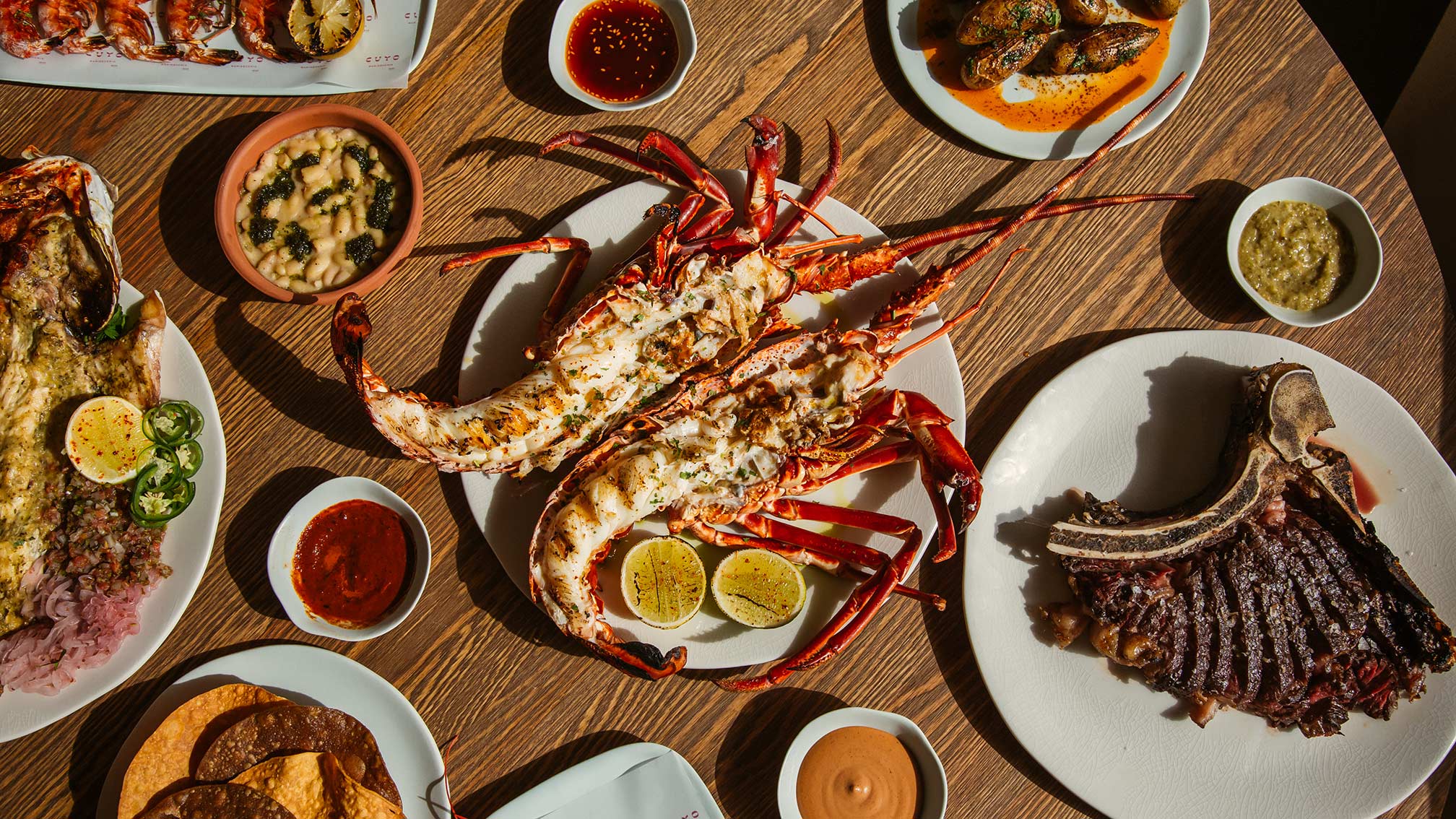 Plate of lobster next to other delicious dishes served at Cuyo in Hyde Ibiza