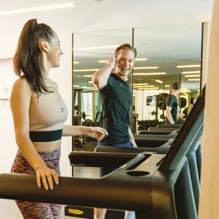 2 people on trreadmills walking next to each other