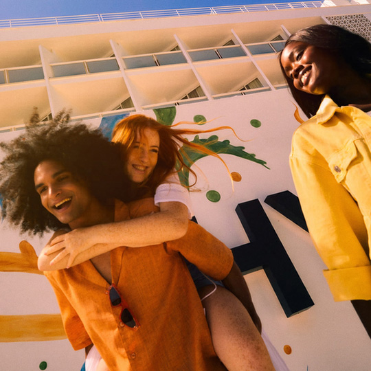 Friends hanging outside the hotel in the sun, laughing