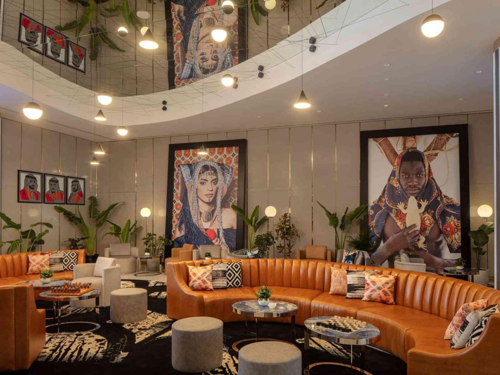 Indoor lounge at Hyde Dubai with orange sofas and decorative prints