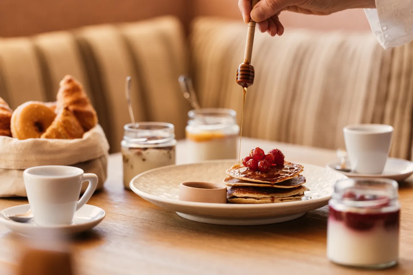 breakfast image with multiple dishes including pancakes and yoghurts