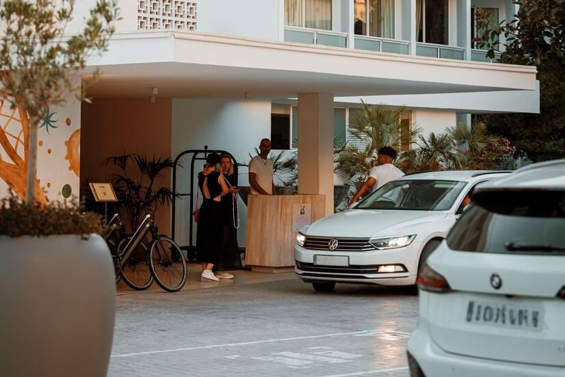 Outside front desk of the Hyde Ibiza property with a couple of white cars and people
