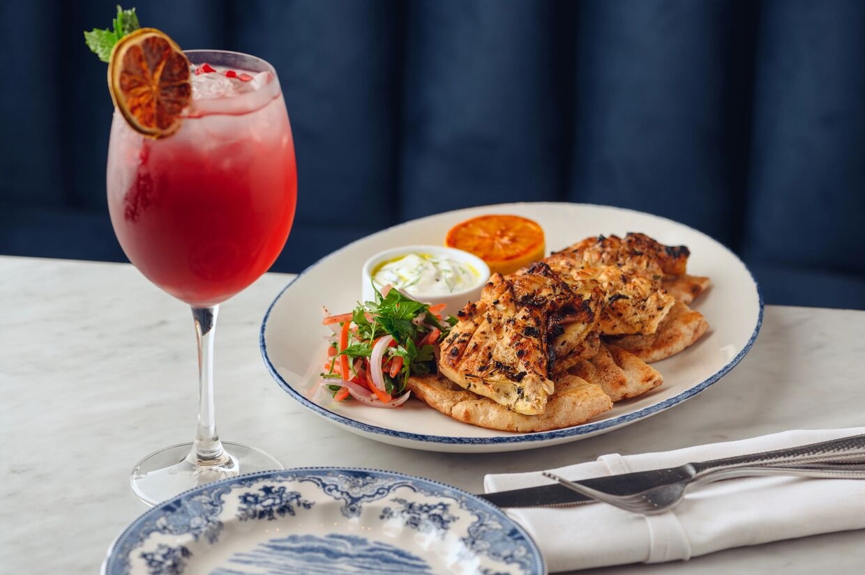 plate with a dish and a pink drink in glass next to it