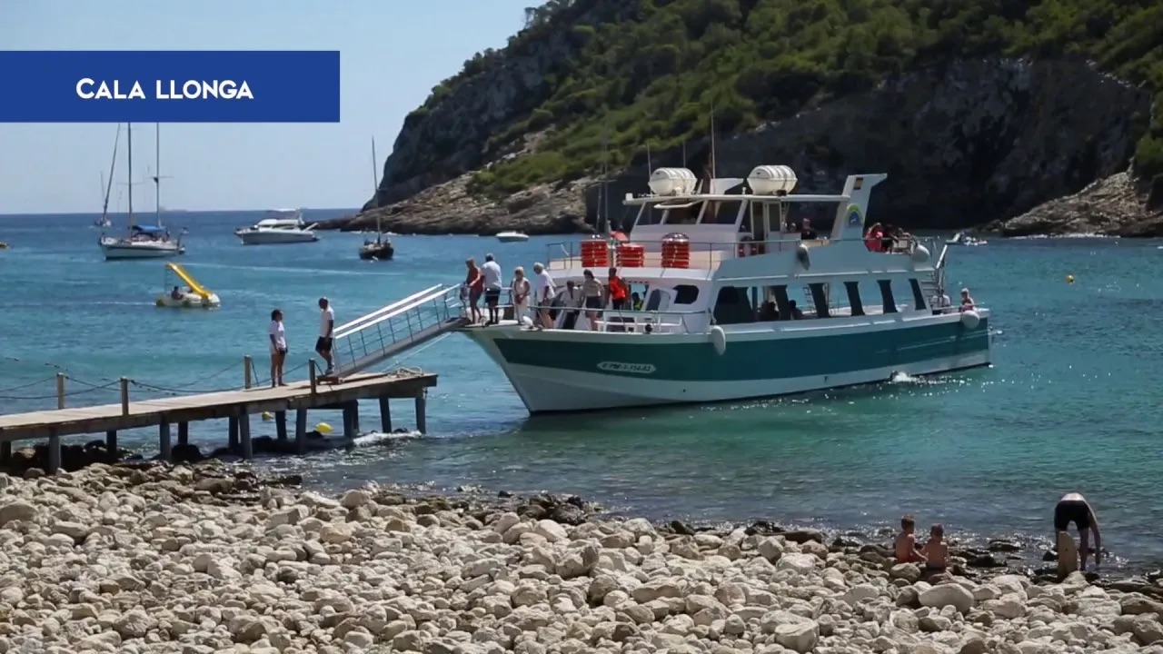 boat being docked on the side of a beach with people coming off board