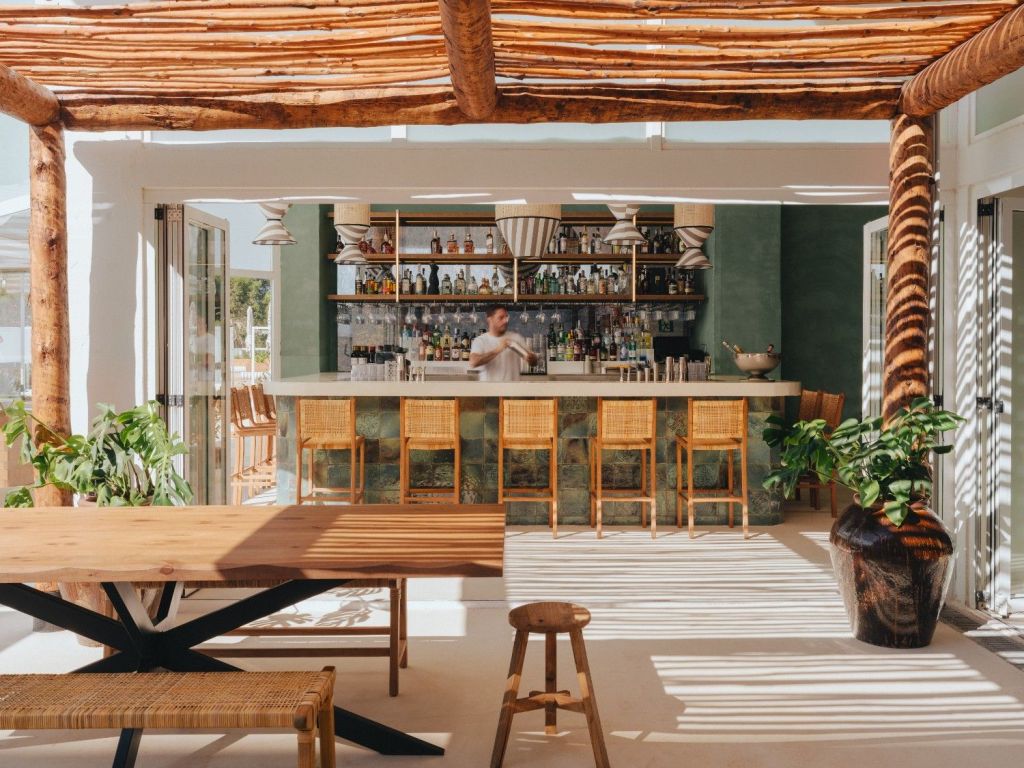 Image du bar Bungalow en extérieur, avec un bar en arrière-plan et des chaises hautes devant.
