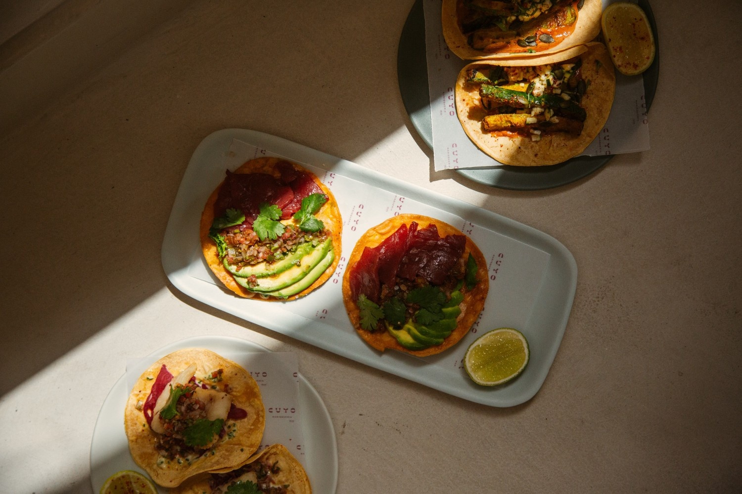 a couple of dishes of Cuyo on a table with shadow closing in