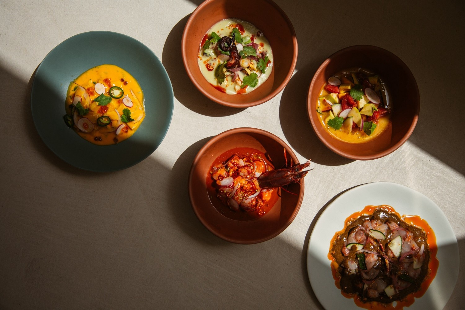 a couple of dishes of Cuyo on a table with shadow closing in