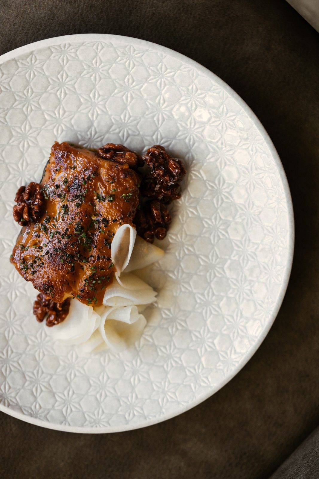 fish dish from Niko on a white plate on a dark table