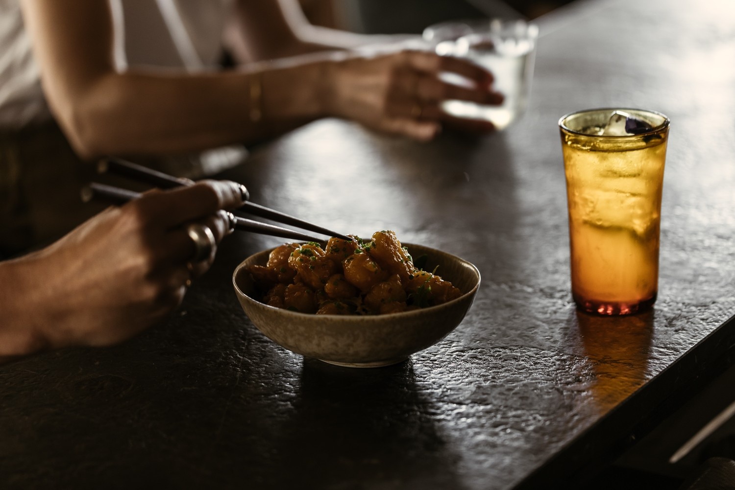 plate of food on dark table with drink next to it