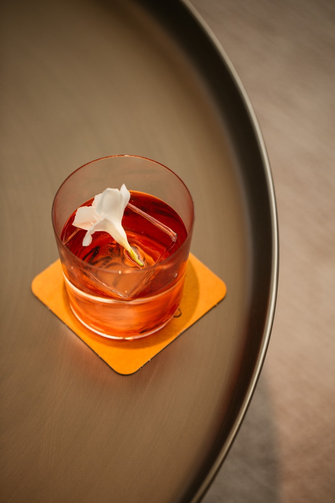 top view of an orange drink on a table with a napkin under it