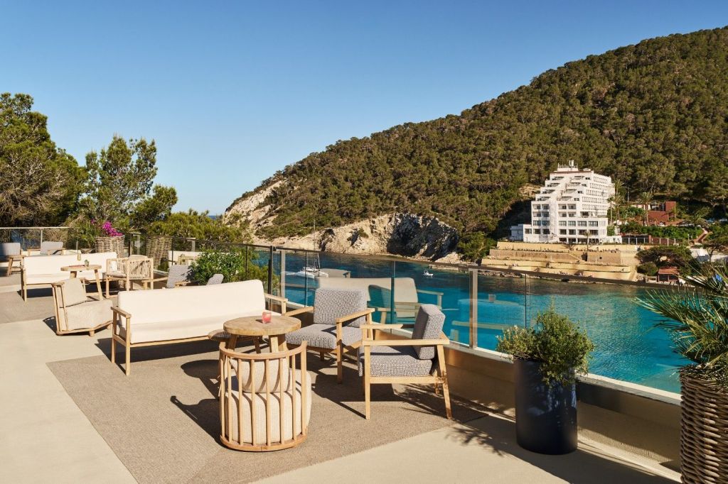 outside terrace showing with multiple seats and tables with a body of water next to it