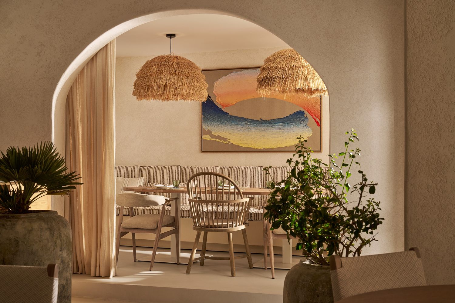 the inside of the restaurant showing an empty table in the background with a big ceiling light above it