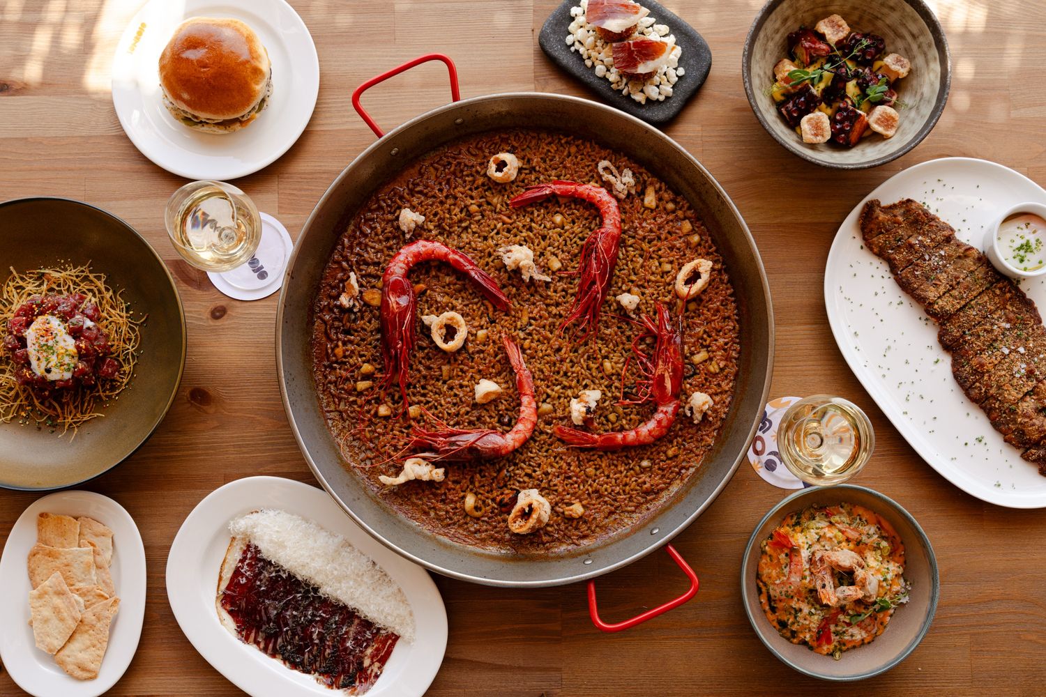 a big paelle plate with some additional plates with food around it