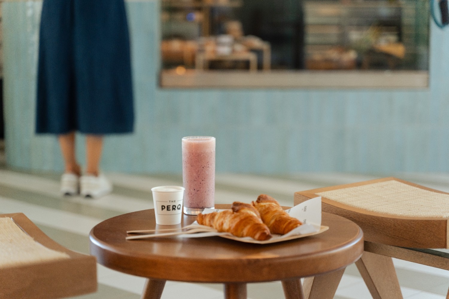 two croissants, a coffee and a smoothie on a table