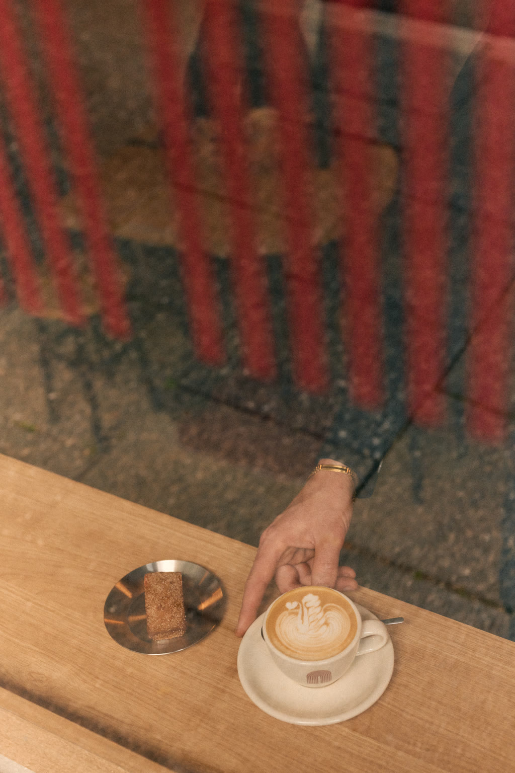 image of a wooden table with a cup of coffee and a plate with a granola bar/cookie