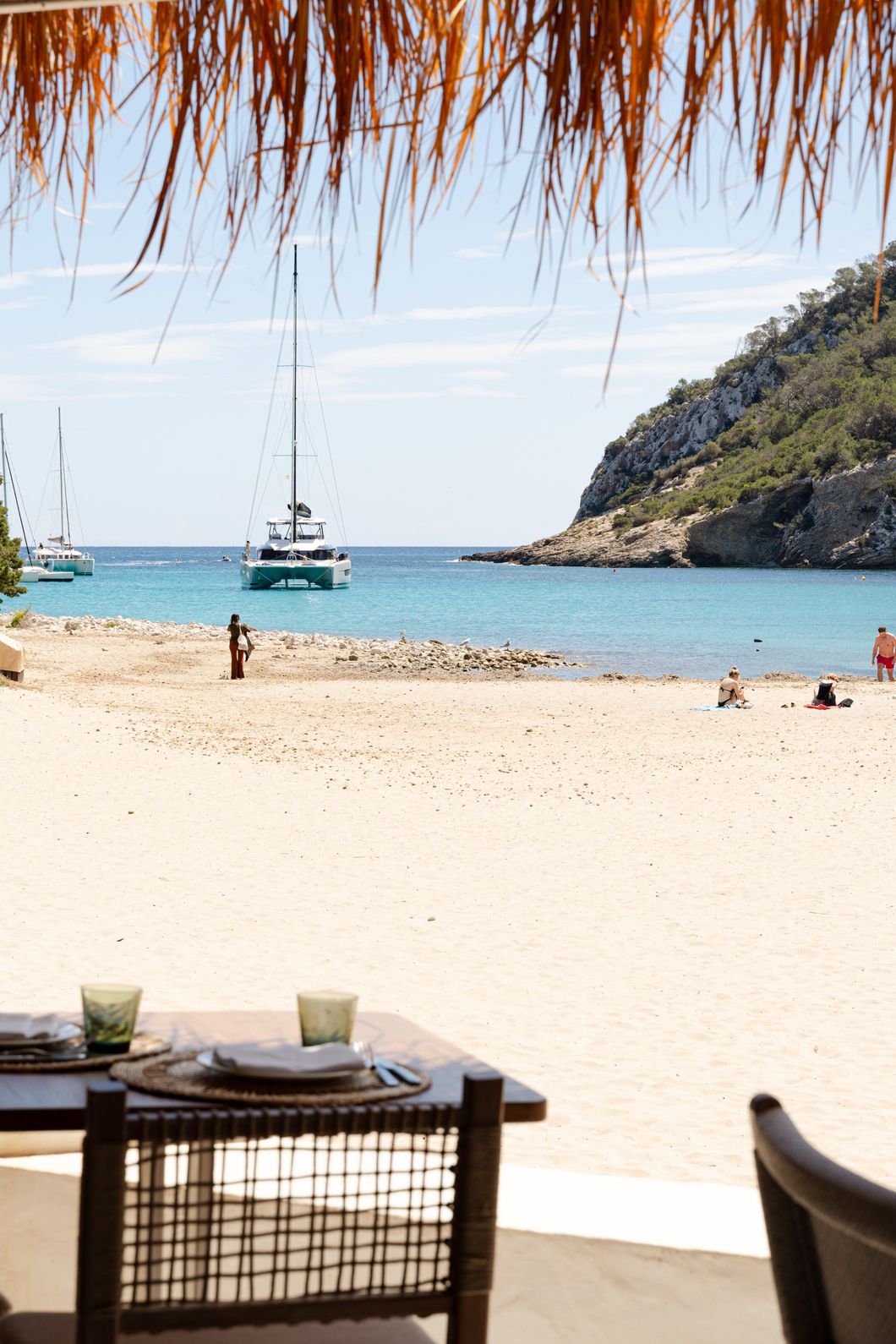 beach image with sea in front of it and a boat in the water