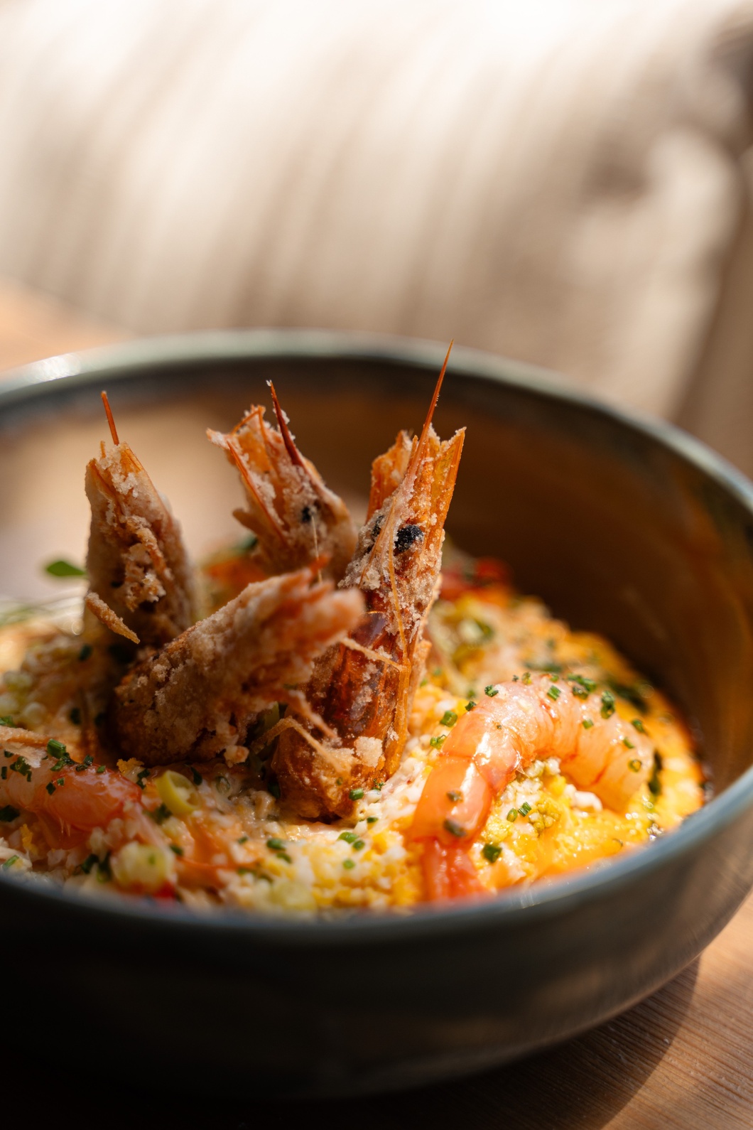 close up of bowl of food with big shrimps on top of it
