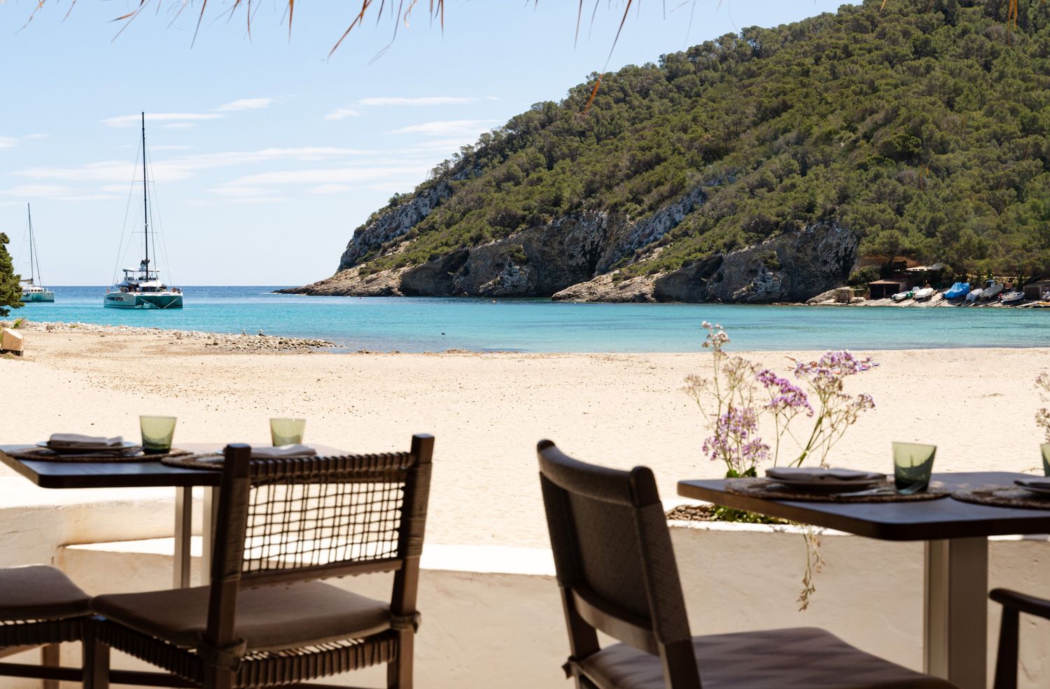 two chairs on a beach with the sand and water in the background