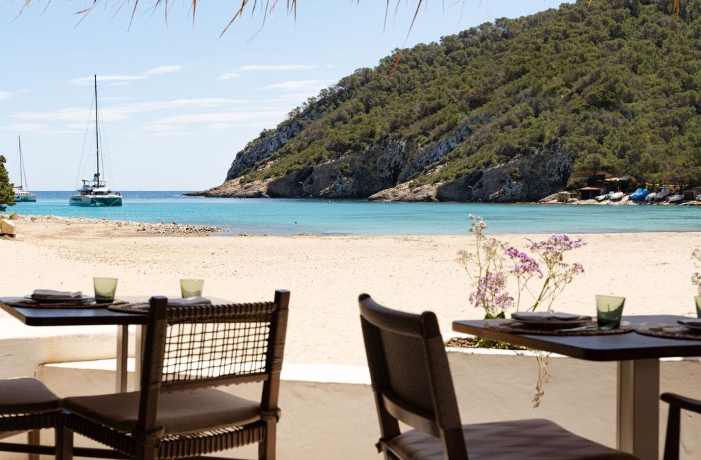 two chairs on a beach with the sand and water in the background