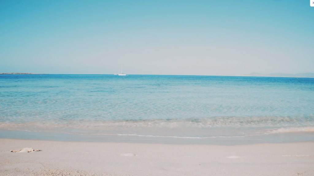 a beach with crystal clear water in front of it