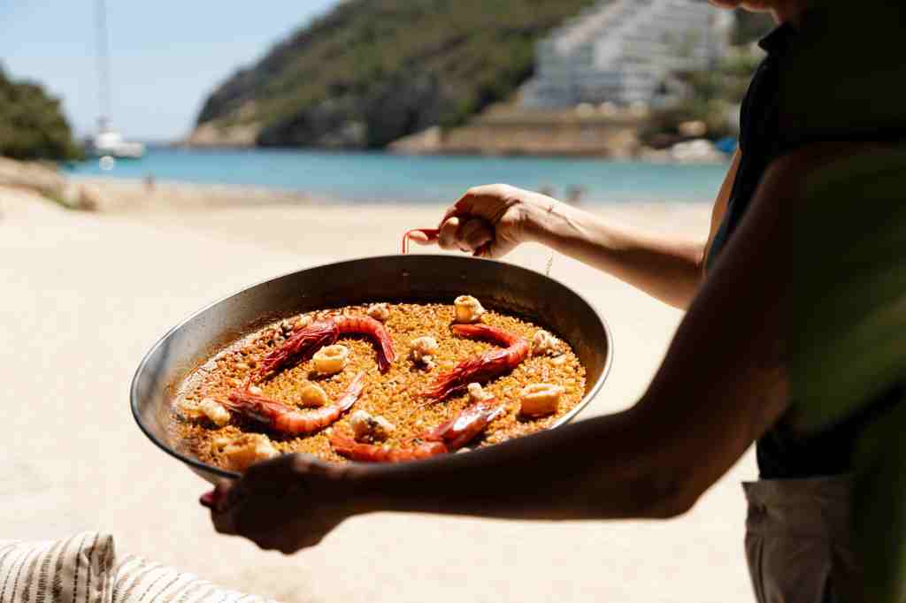 Person holding a pan of paella at the Sonjoro restaurant at Hyde Ibiza.