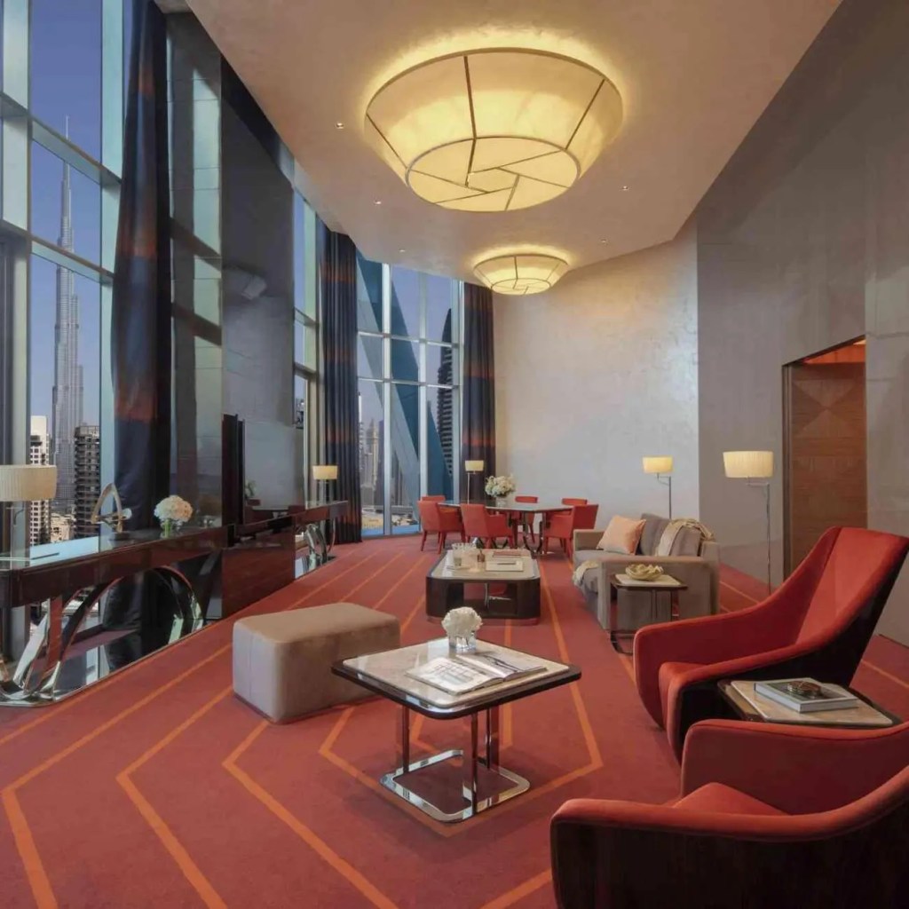 rockstar suite with big light on the ceiling, multiple seats around the living area and glass window on the left