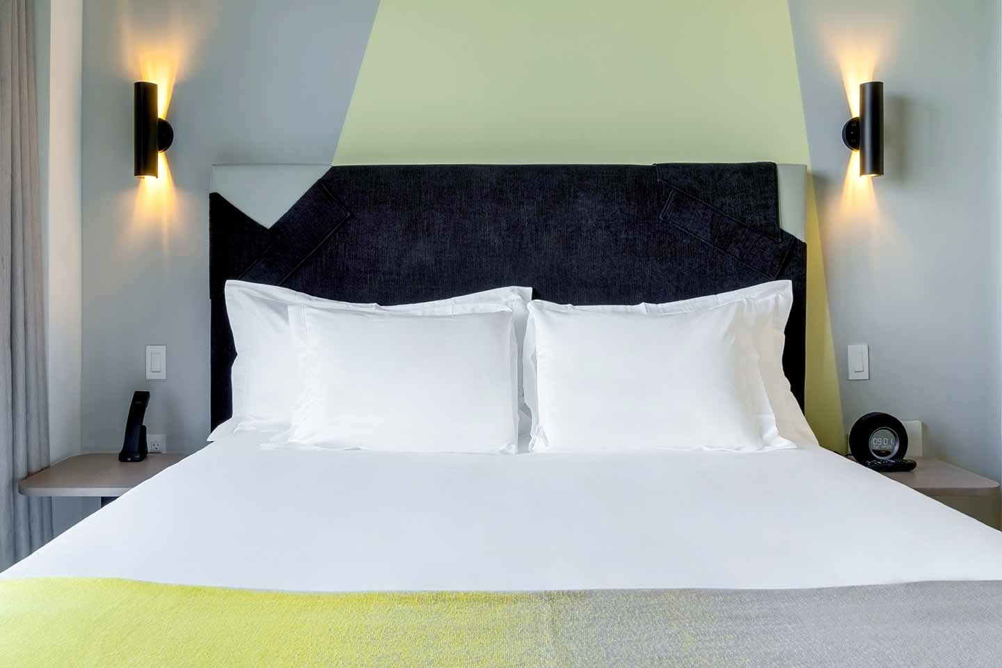 A double bed with bedside lights on each side