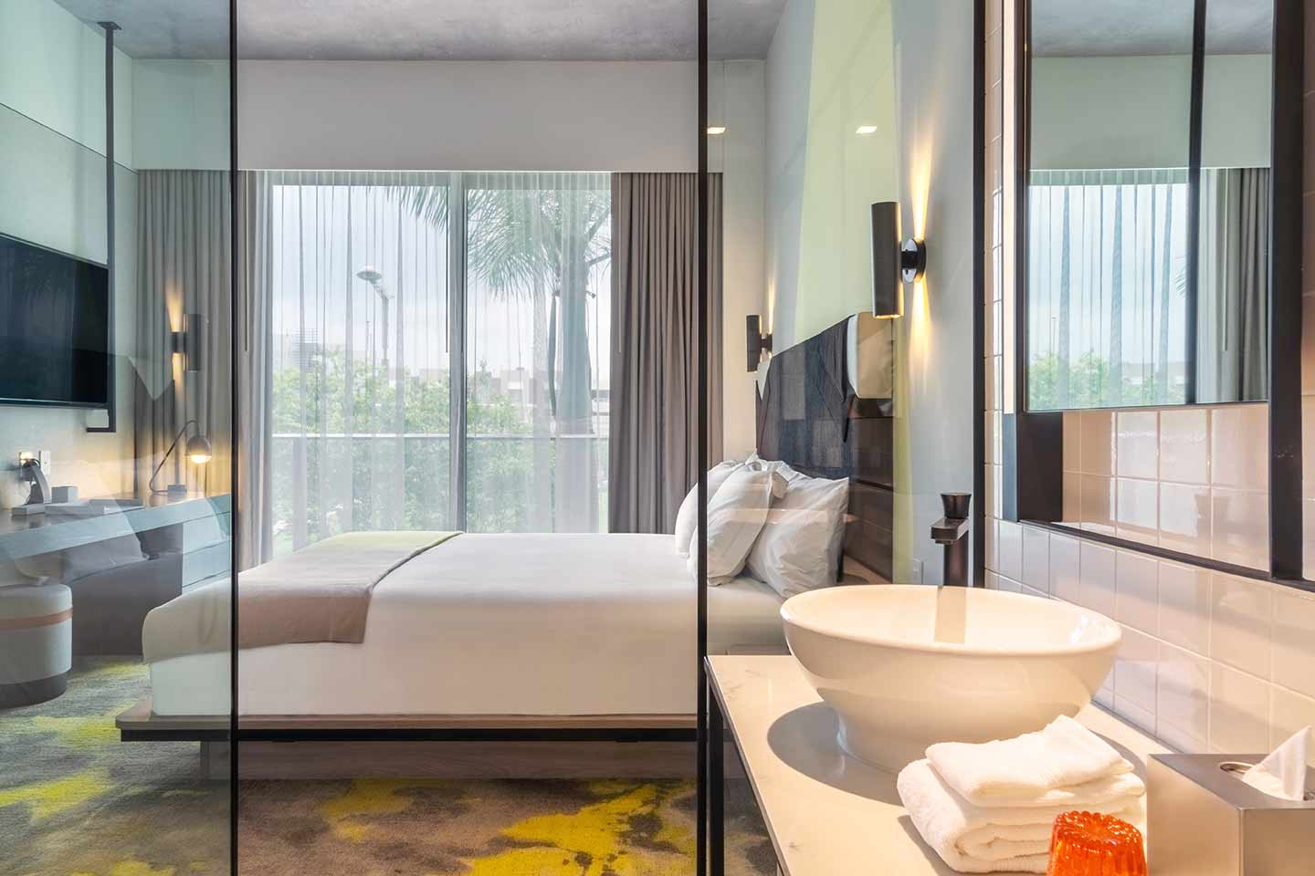 Bedroom at Hyde Midtown Miami with ensuite sink area at the forefront with glass divider
