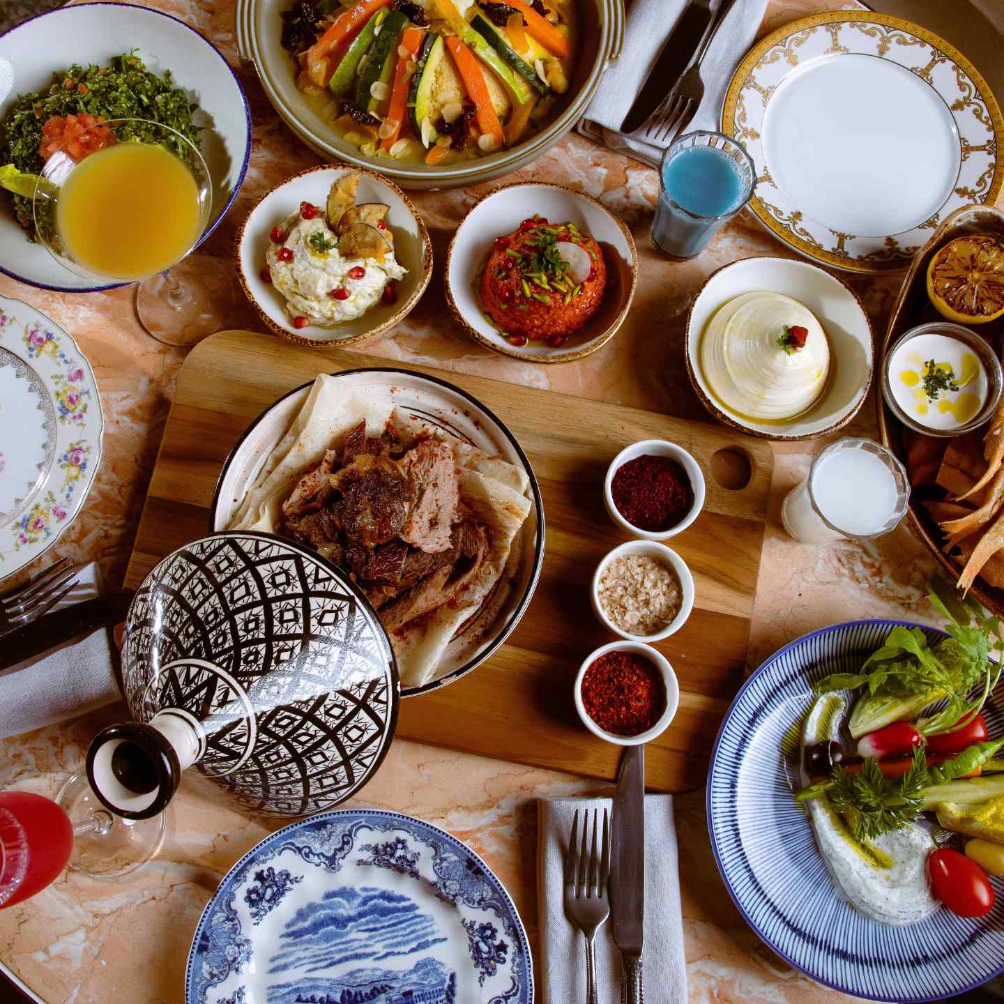 Wooden table with multiple mediterranean dishes of food on it