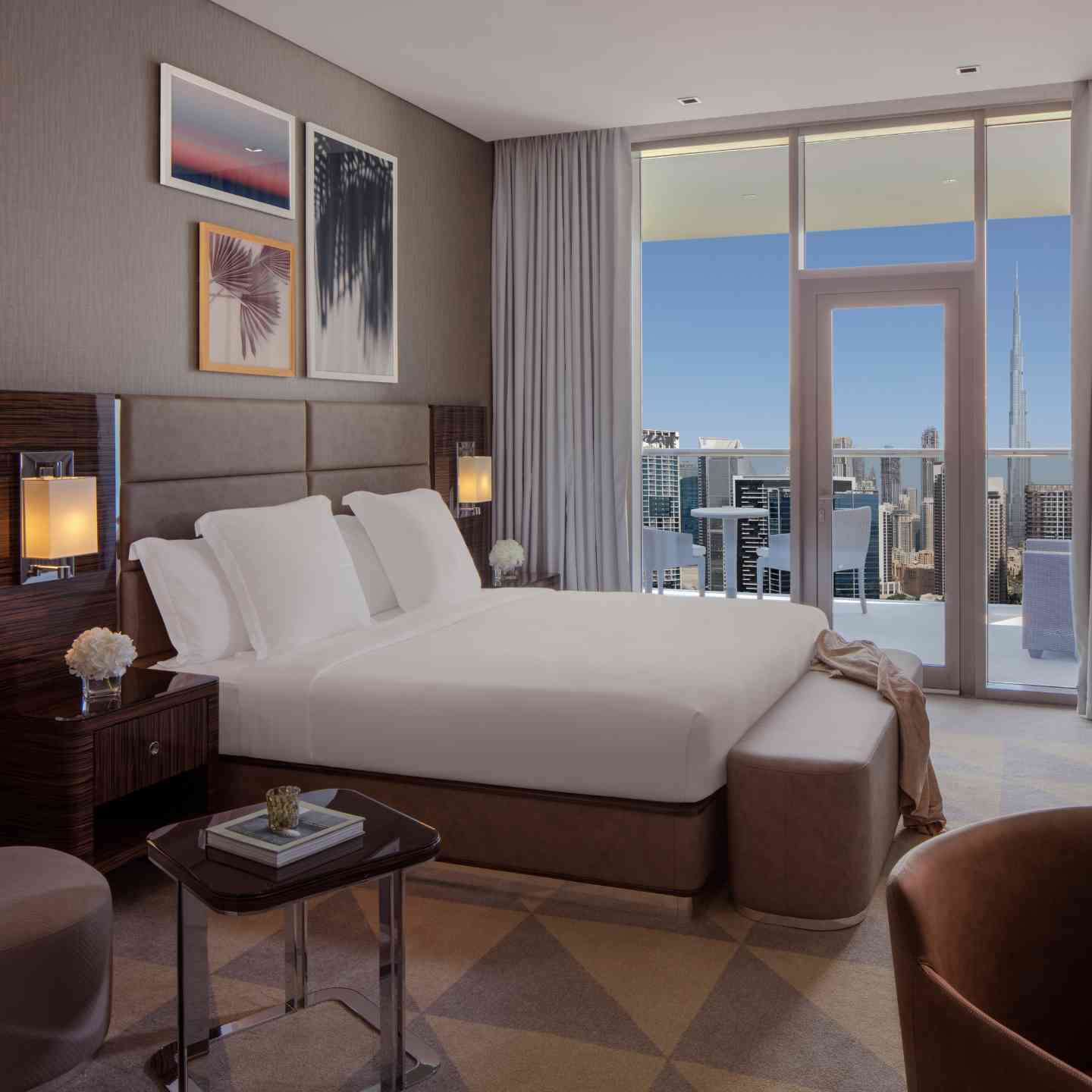 King bed with gray headboard, two lights on each side of bed, large floor to ceiling windows with view of Dubai cityscape and the Burj Khalifa
