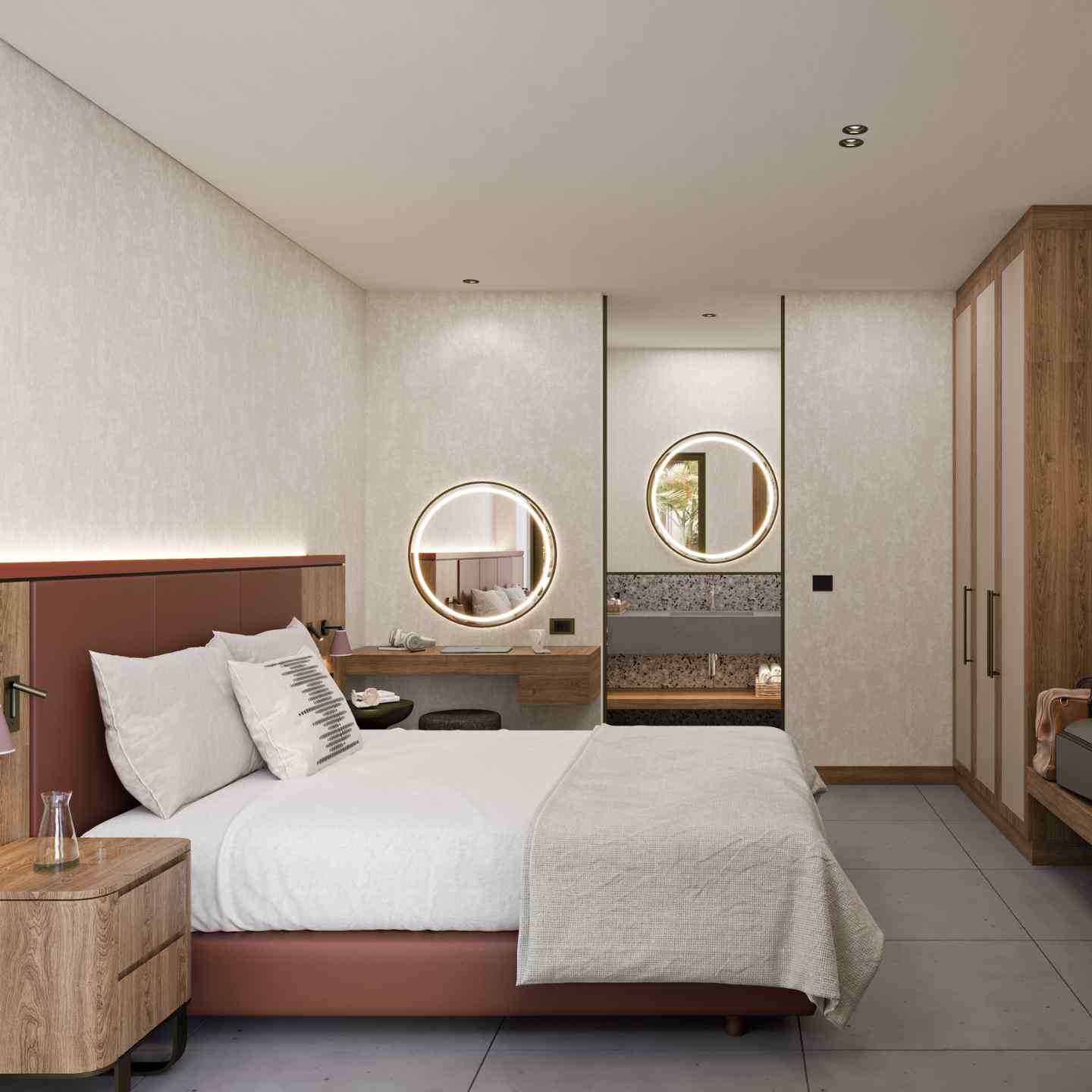 Side of large bed with wooden frame and beige bedding with small wooden bedside table, and two round circular mirrors on the walls, and wardrobe in the background