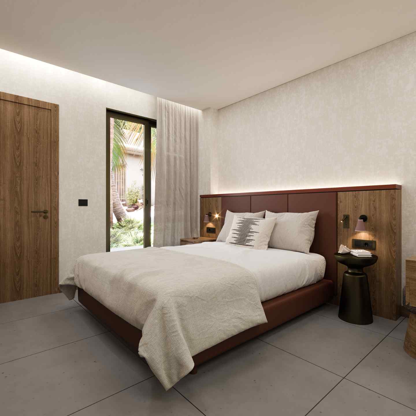 Angle of large bed with beige bedding and wooden bed frame, small dark bedside table, and sliding balcony door in the background