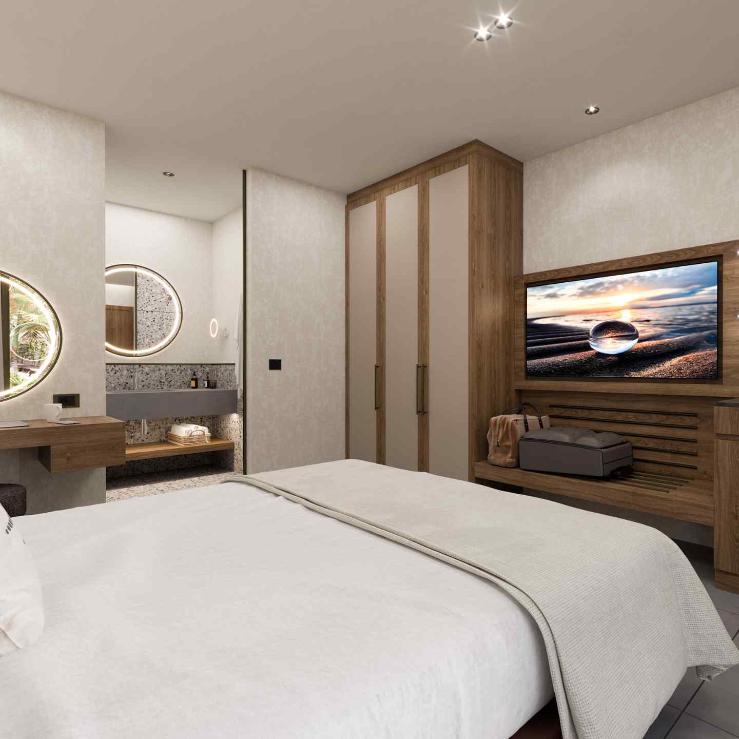 Corner of bed facing a wall with wooden console and wide screen tv, wardrobe in the background, and circular mirrors on wall