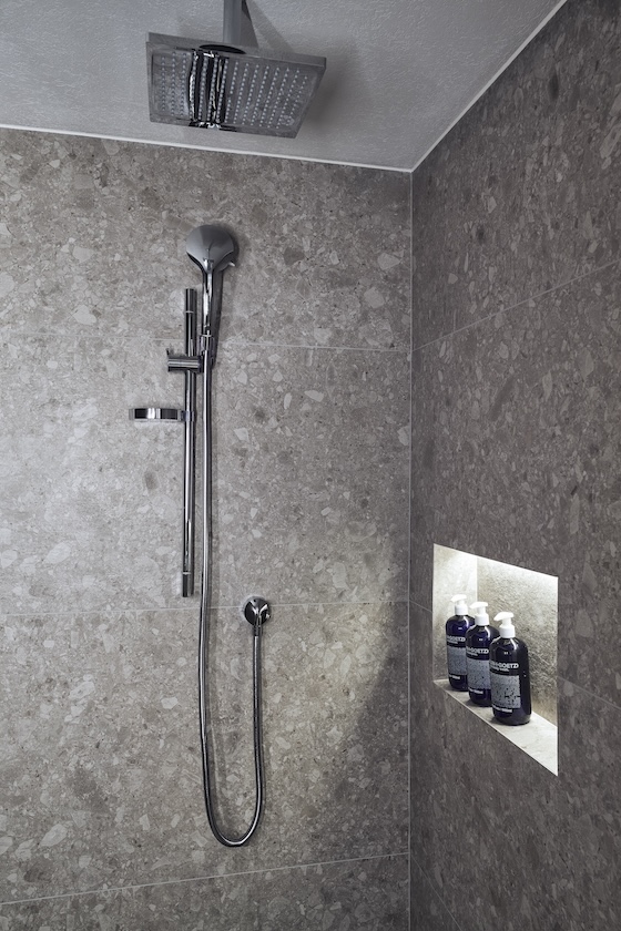 Grey walk in shower with soaps