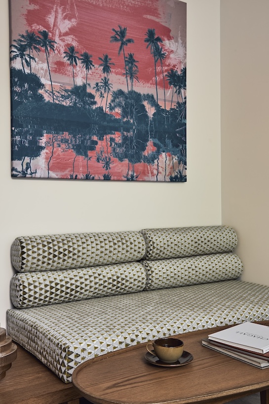 Upholstered bench with coffee table and colorful artwork hanging on the wall