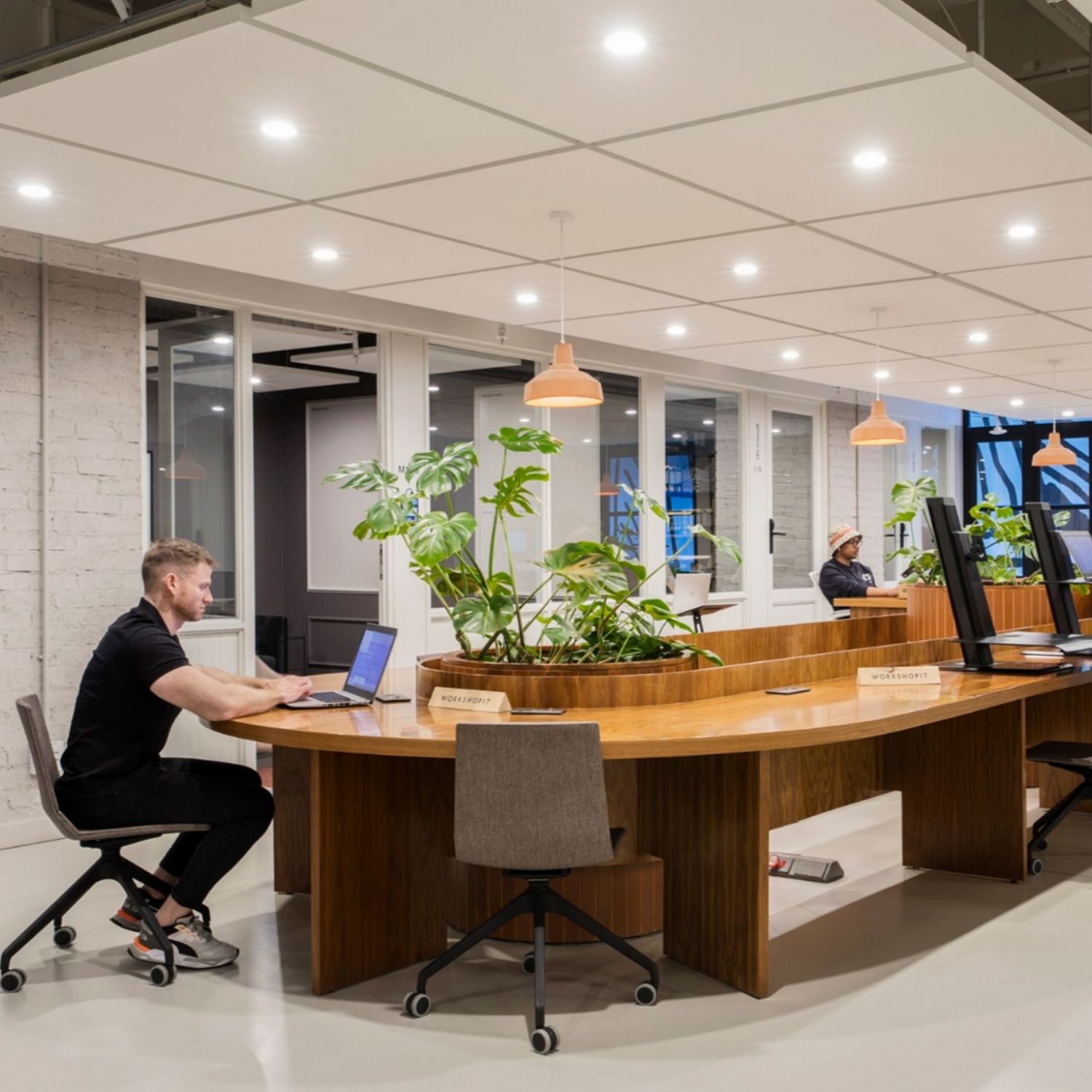 open workspace with an oval-shaped table, plants placed in the middle of the table in Hyde Johannesburg.