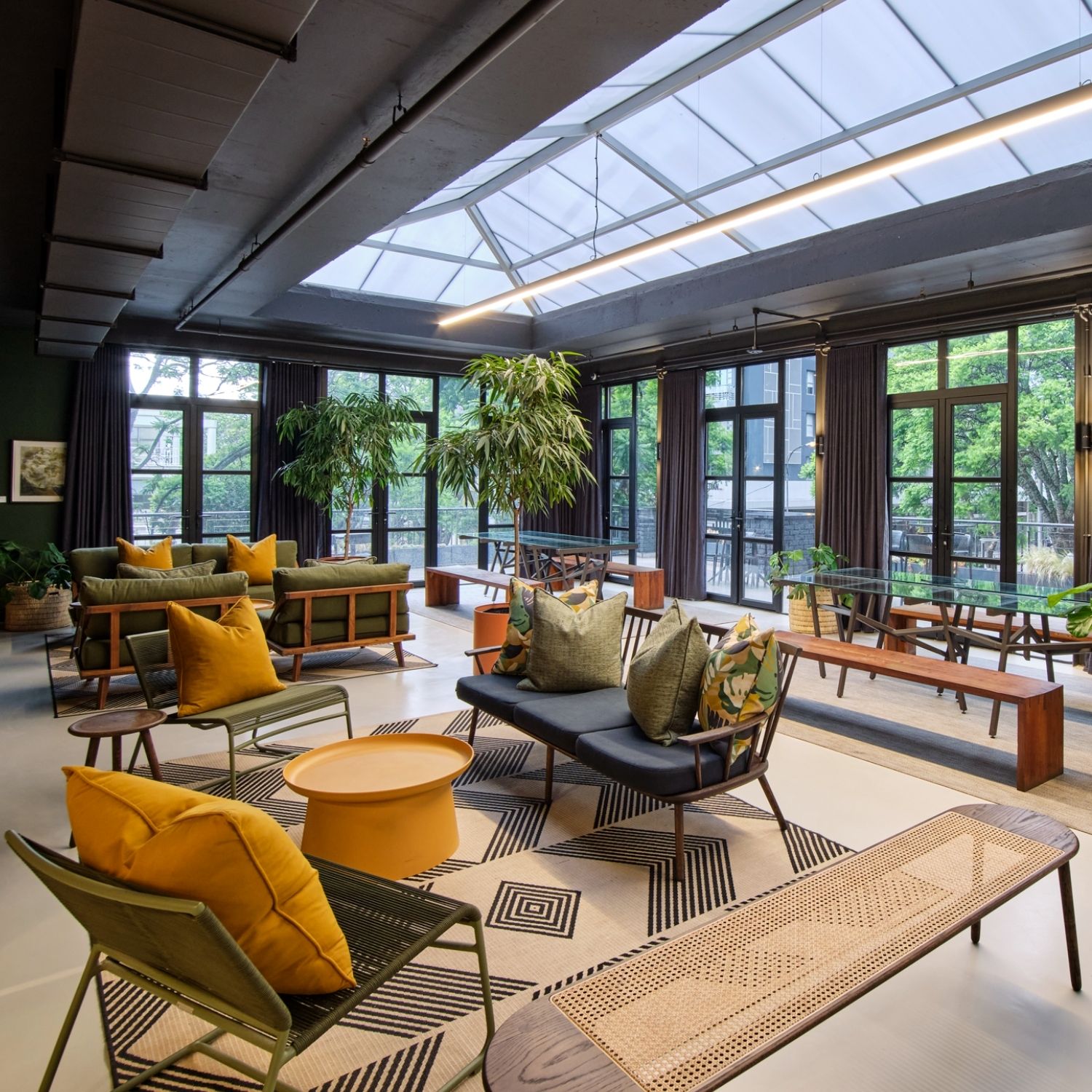 Open workspace in Hyde Johannesburg with chairs placed around the room, tables in between, and wooden benches.