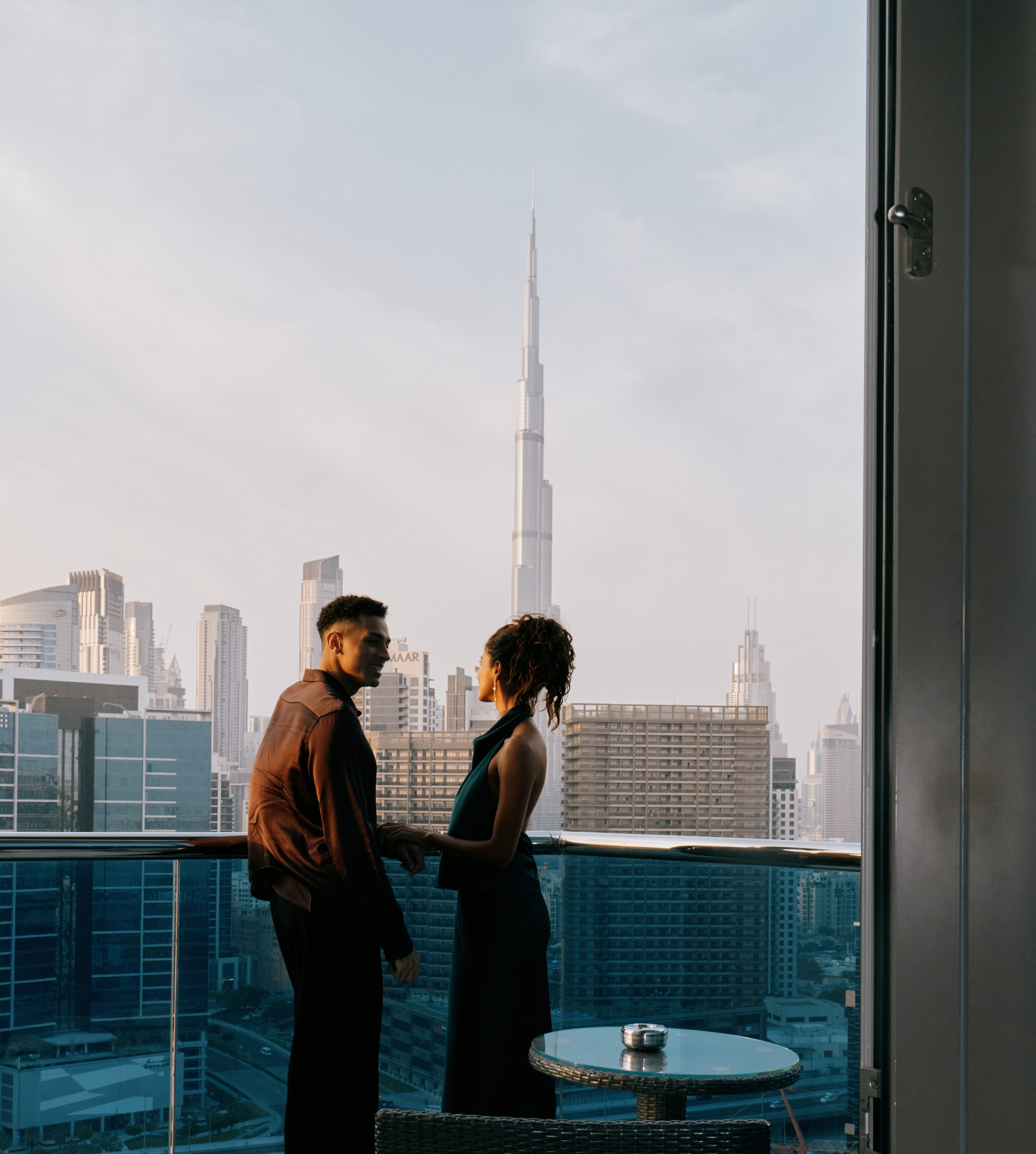Couple on a balcony with Burj Khalifa and Dubai skyline background